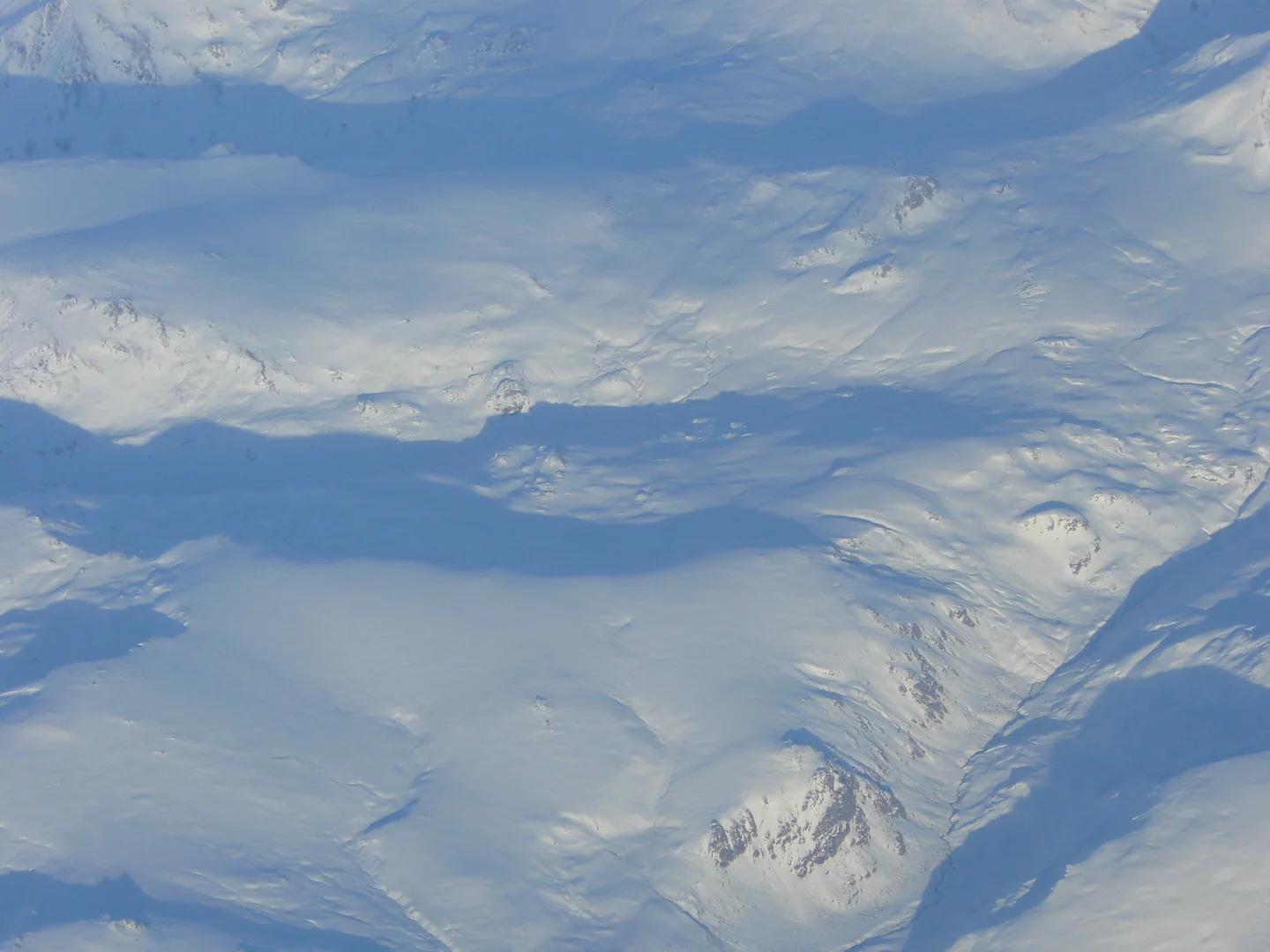 Snowy mountains and ice fields stretch across a vast, frozen landscape.