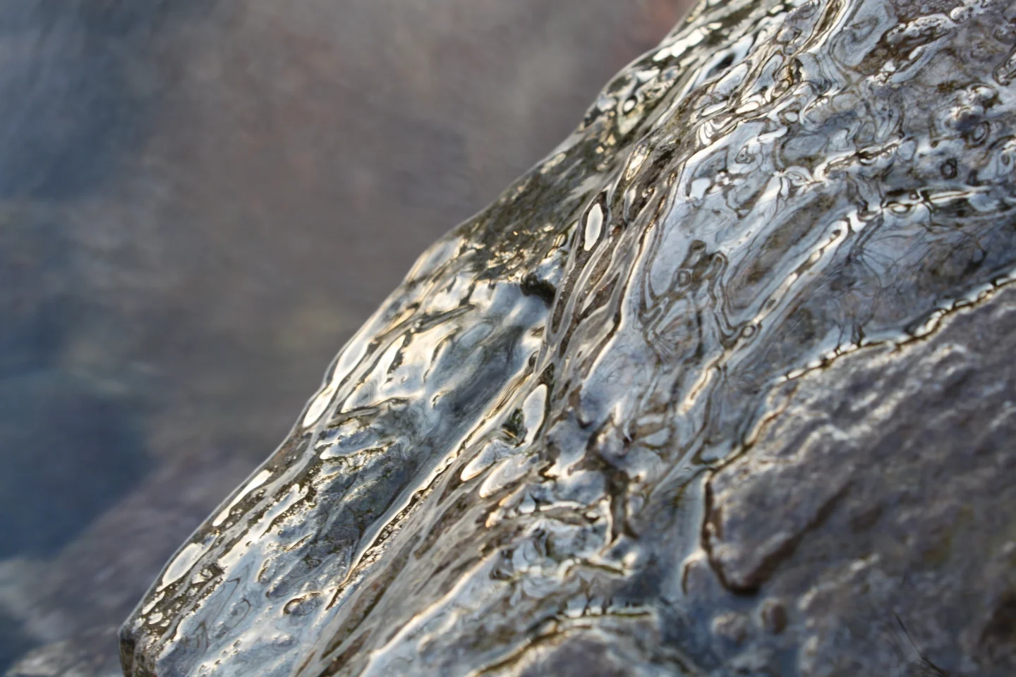Springwater floating over a boulder reflecting the evening sky