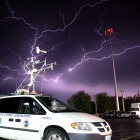 Lightning strike with a stormchase vehicle used in VORTEX2 in the foreground.