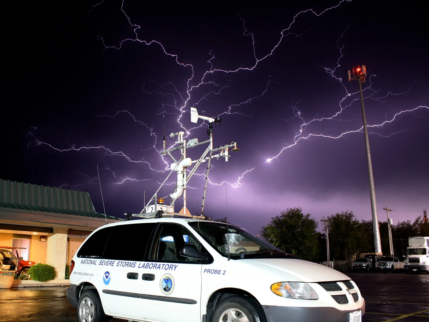 Lightning strike with a stormchase vehicle used in VORTEX2 in the foreground.