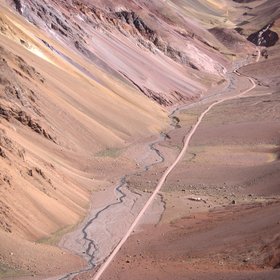 Fluvial landslope dynamics in a high mountain valley with an international road