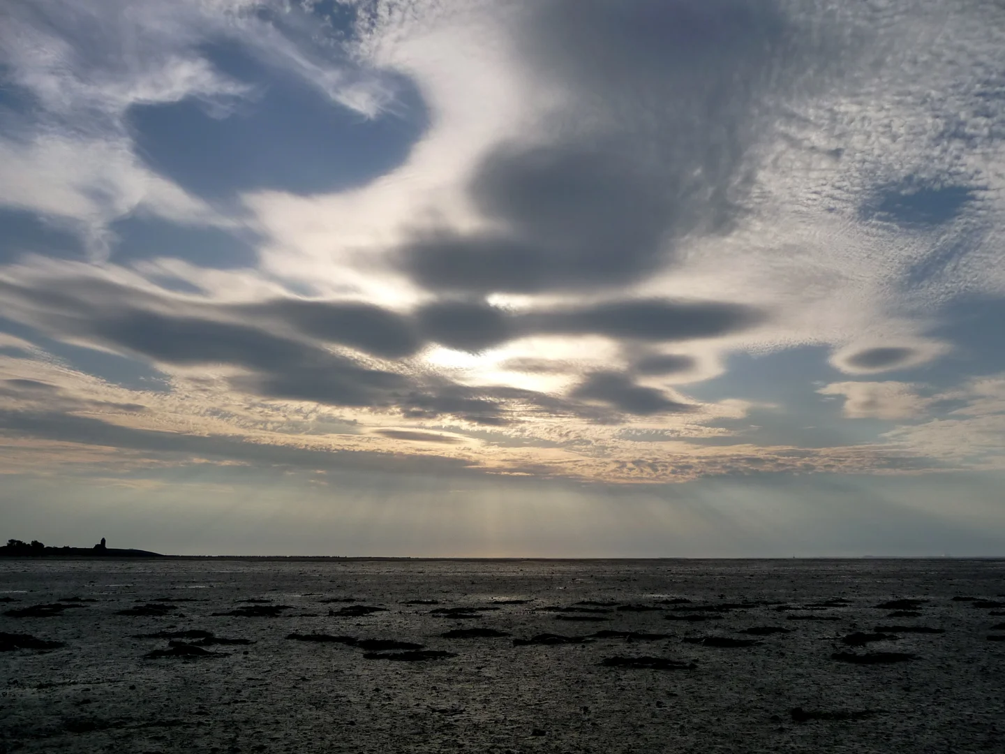 Sunbeams over dry mudflat of the Wadden sea