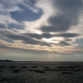 Sunbeams over dry mudflat of the Wadden sea