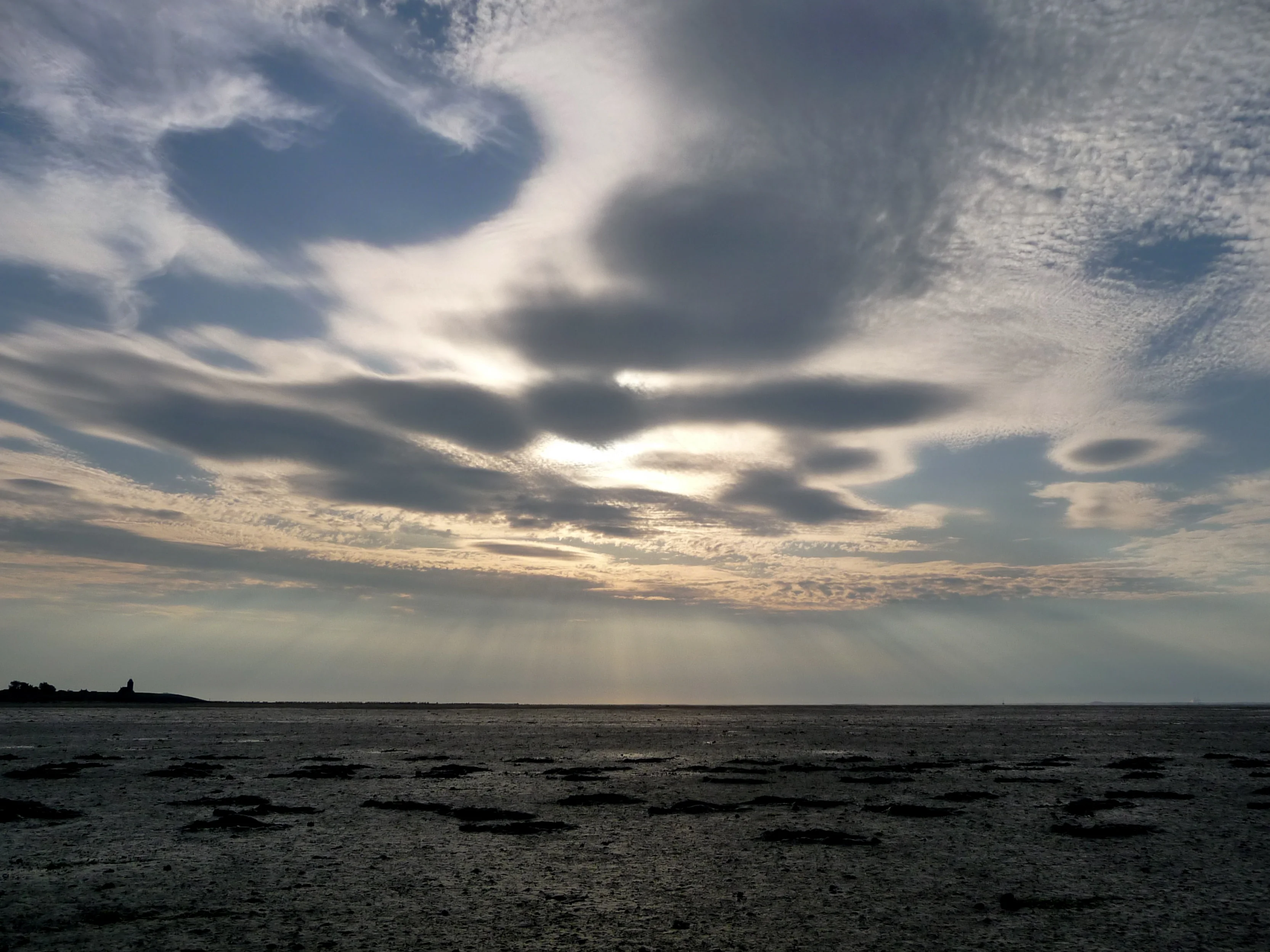 Sunbeams over dry mudflat of the Wadden sea