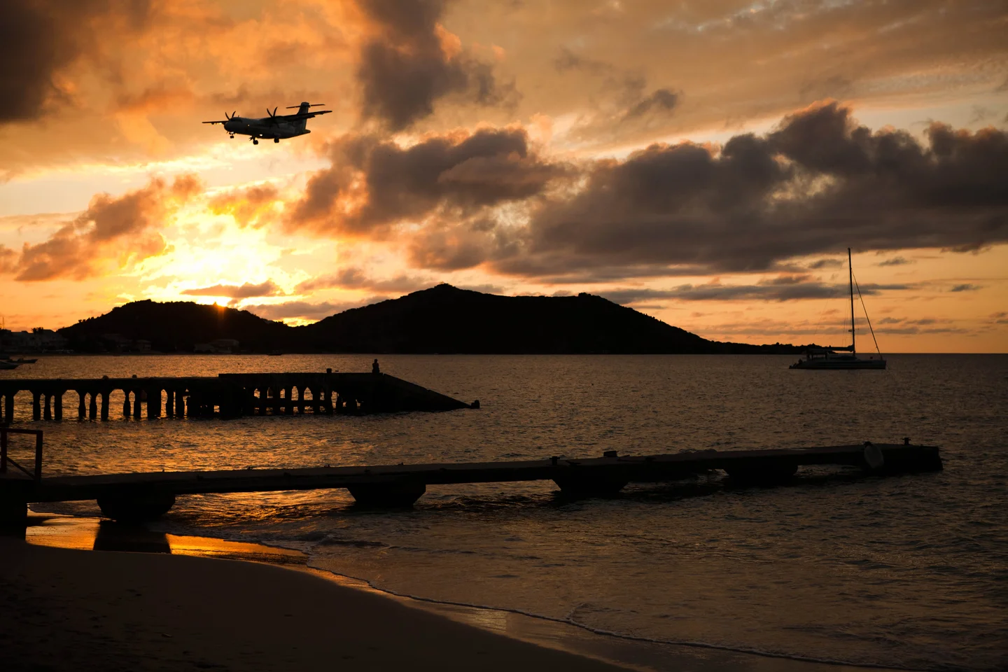 An airplane lands, a sailboat leaves