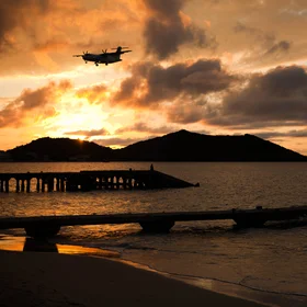 An airplane lands, a sailboat leaves