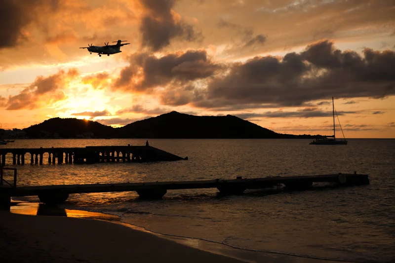 An airplane lands, a sailboat leaves