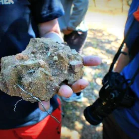 Soil science students observing a blocky aggregate in the field