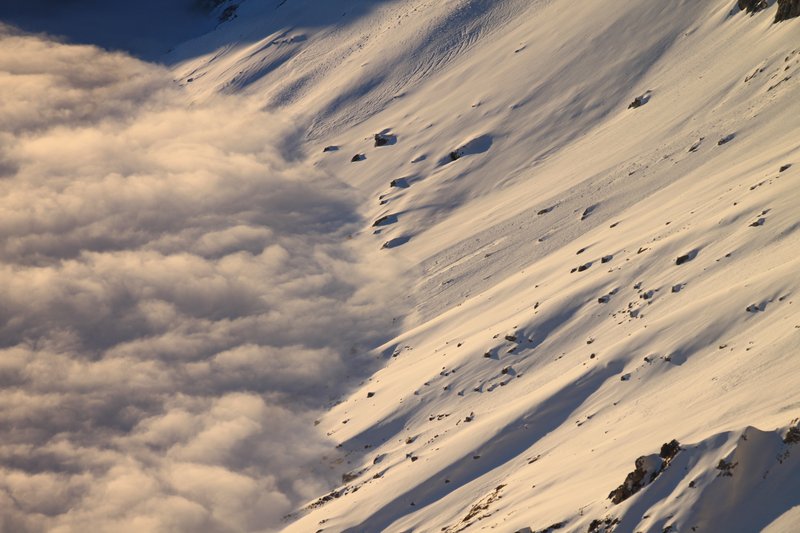 Clouds, snow and the sun on a mountain slope