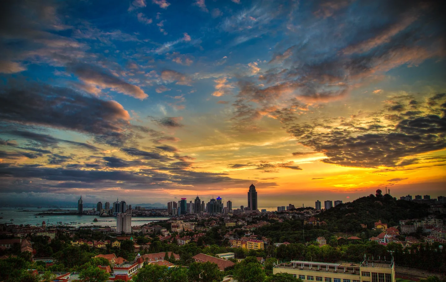 The red roofs, green trees, blue sea, azure sky, architectures form a bright and colorful picture of Qingdao.