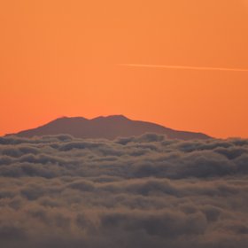 Summit of Mount Etna over a clouds carpet