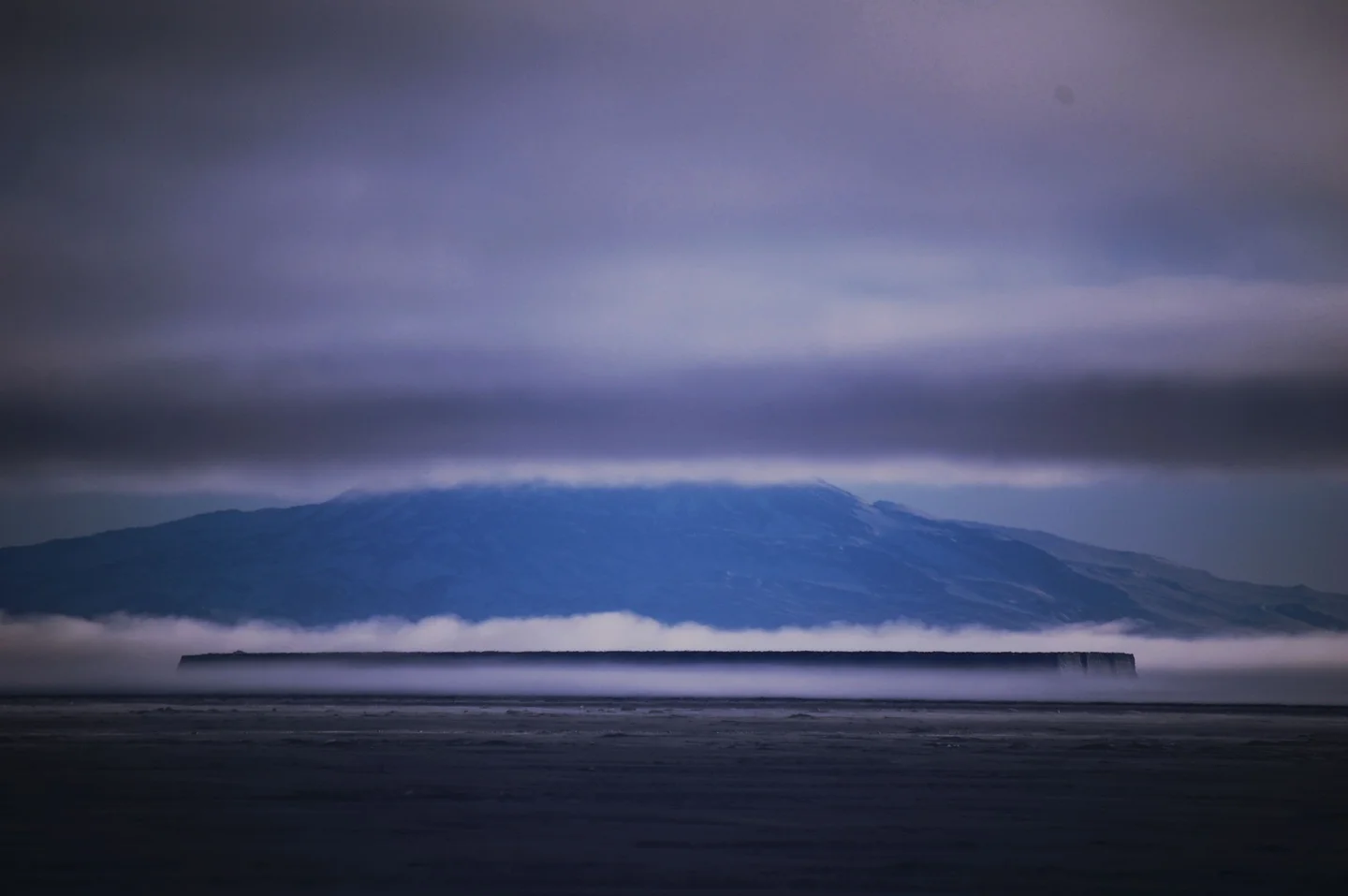 Seafog engulfs a grounded iceberg