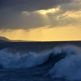 Sun, breaking waves and spray