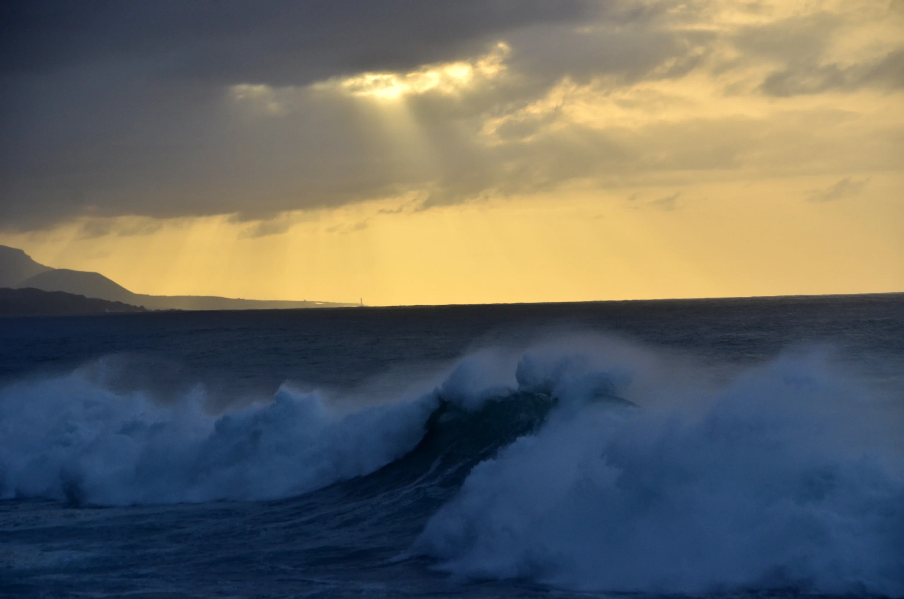 Sun, breaking waves and spray