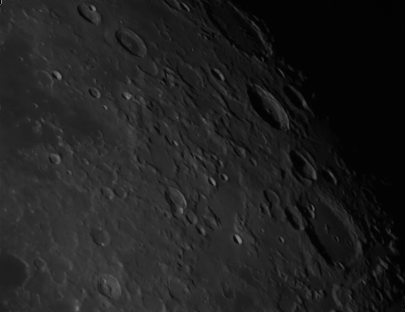 Cratered lunar surface with varying shadow contrasts.
