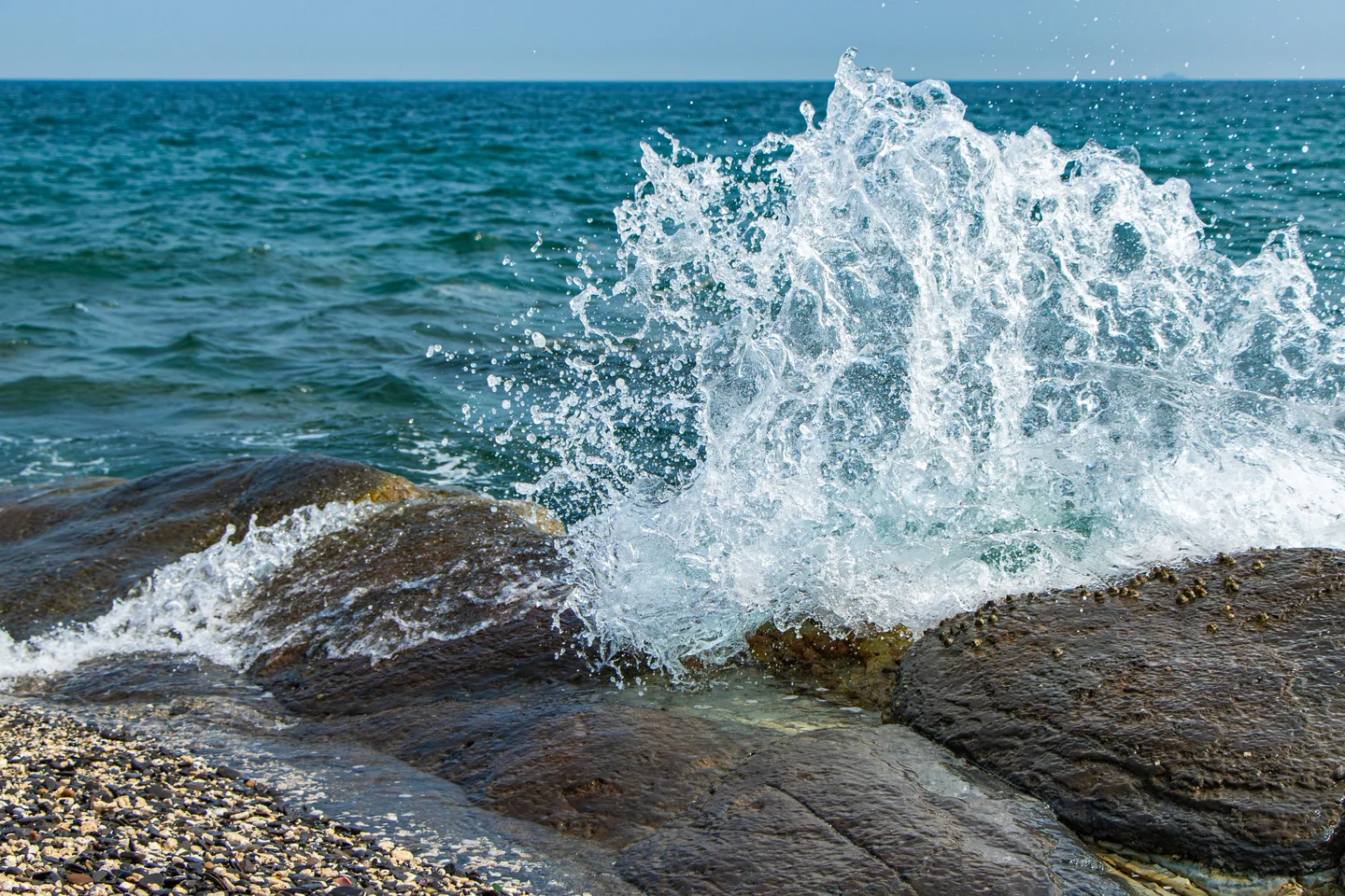 Catch the wave hitting on the rocks