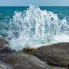 Catch the wave hitting on the rocks
