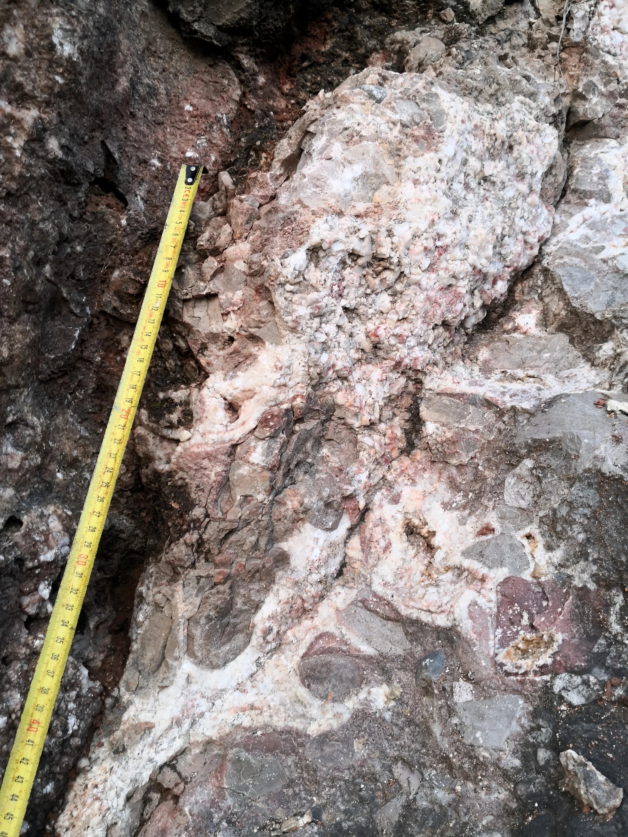 Fault acting as a pathway for hydrothermal fluid that precipitated large pink calcite crystals along the way