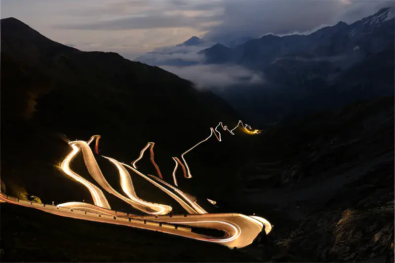 Moving lights at night on mountain road at Stelvio Pass