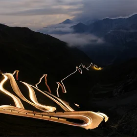 Moving lights at night on mountain road at Stelvio Pass