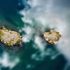 Two little islands in a mirror of clouds