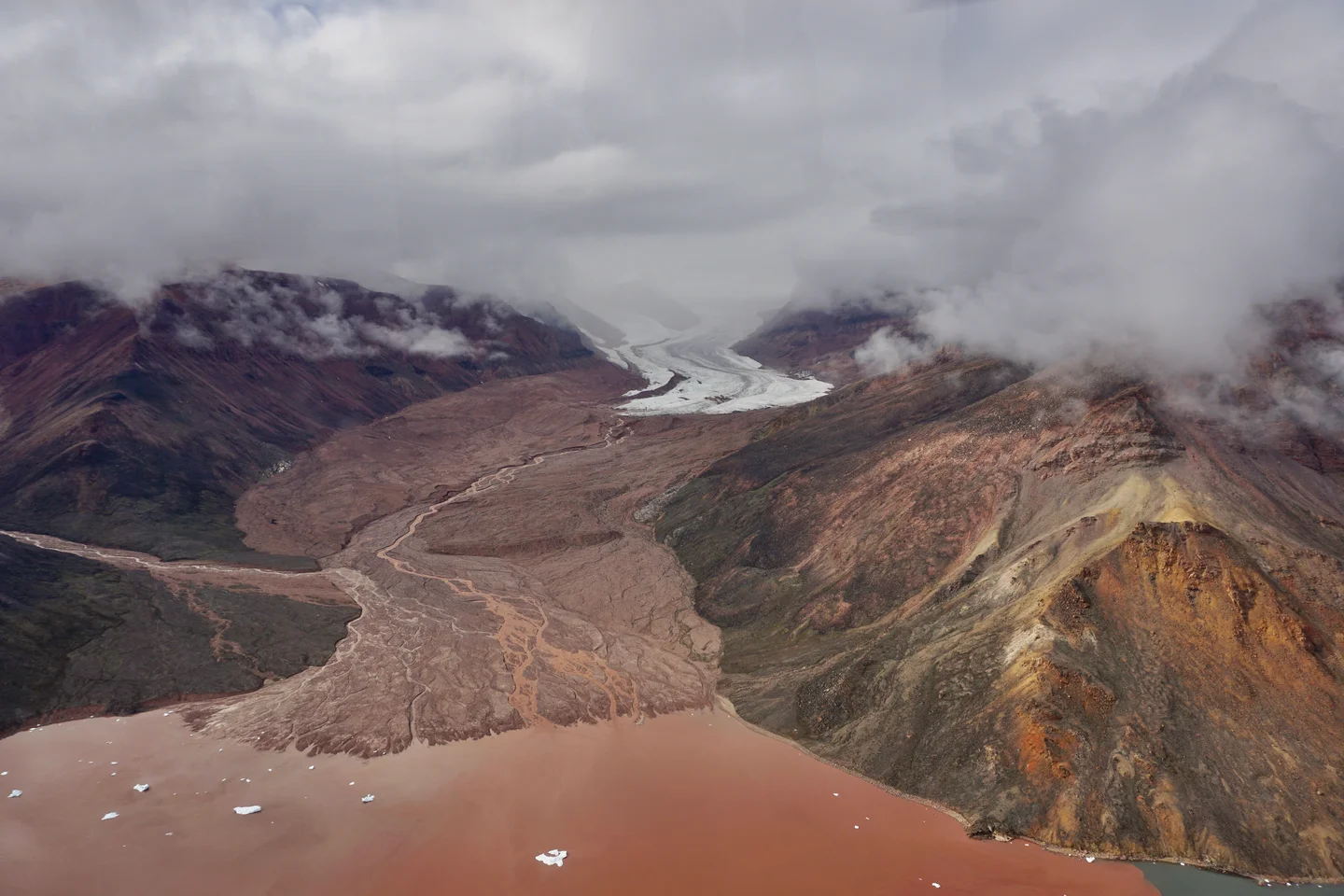 Iron rich glacier runoff to sea shore Qaanaaq island -  Greenland