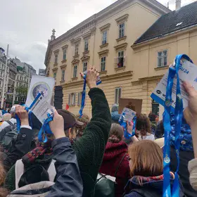 EGU scientists holding up their badges at a climate protest