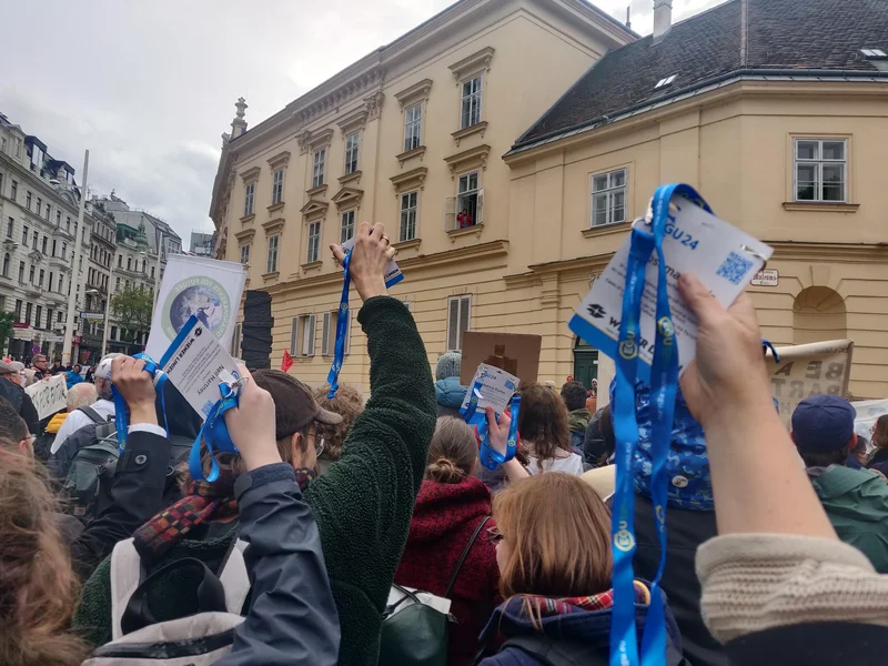 EGU scientists holding up their badges at a climate protest