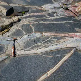 Metamorphic complex with amphibolite enclaves crossed by two generations of granitic veins