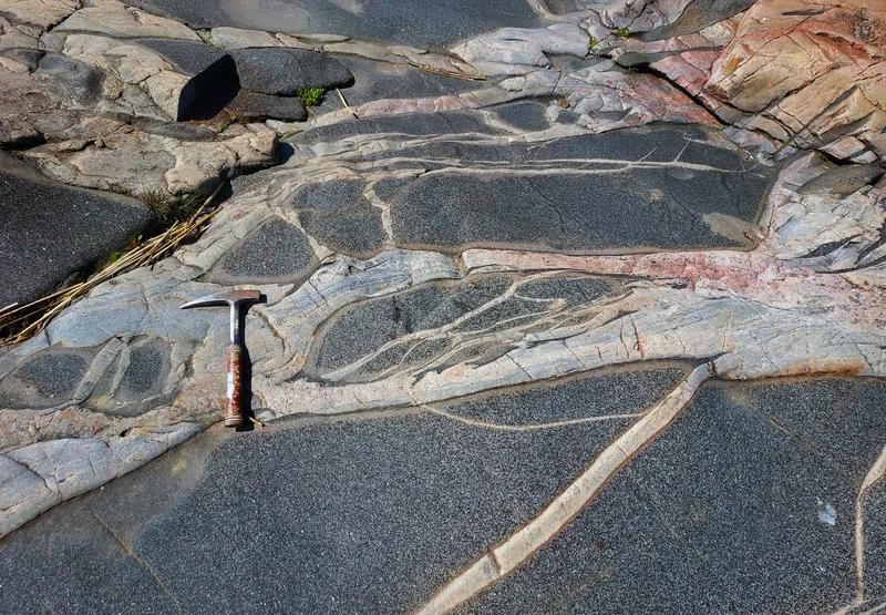 Metamorphic complex with amphibolite enclaves crossed by two generations of granitic veins