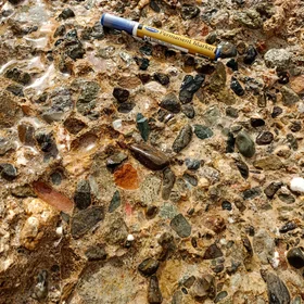 Well-sorted Marine Clastics (medium- to coarse-sized) embedded within iron-oxides cement