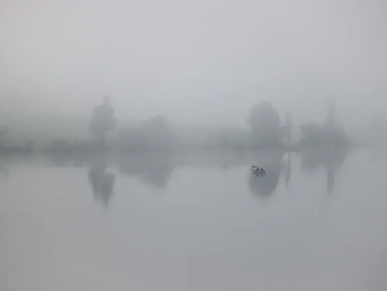 A silent lake veiled in pale mist