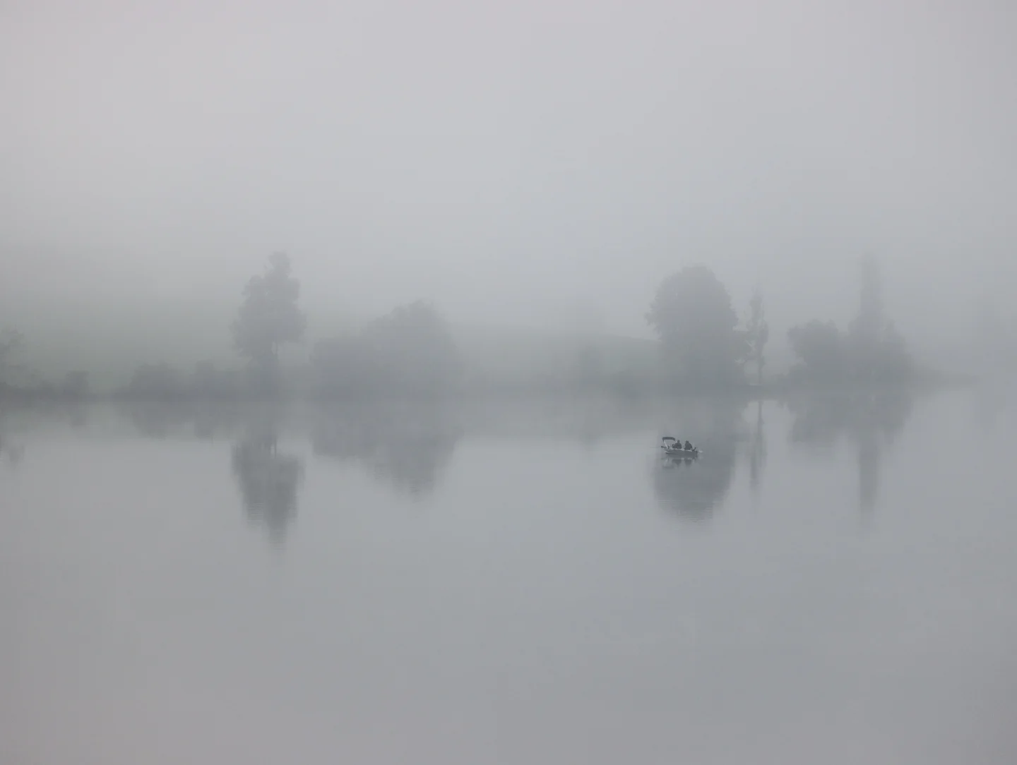 A silent lake veiled in pale mist