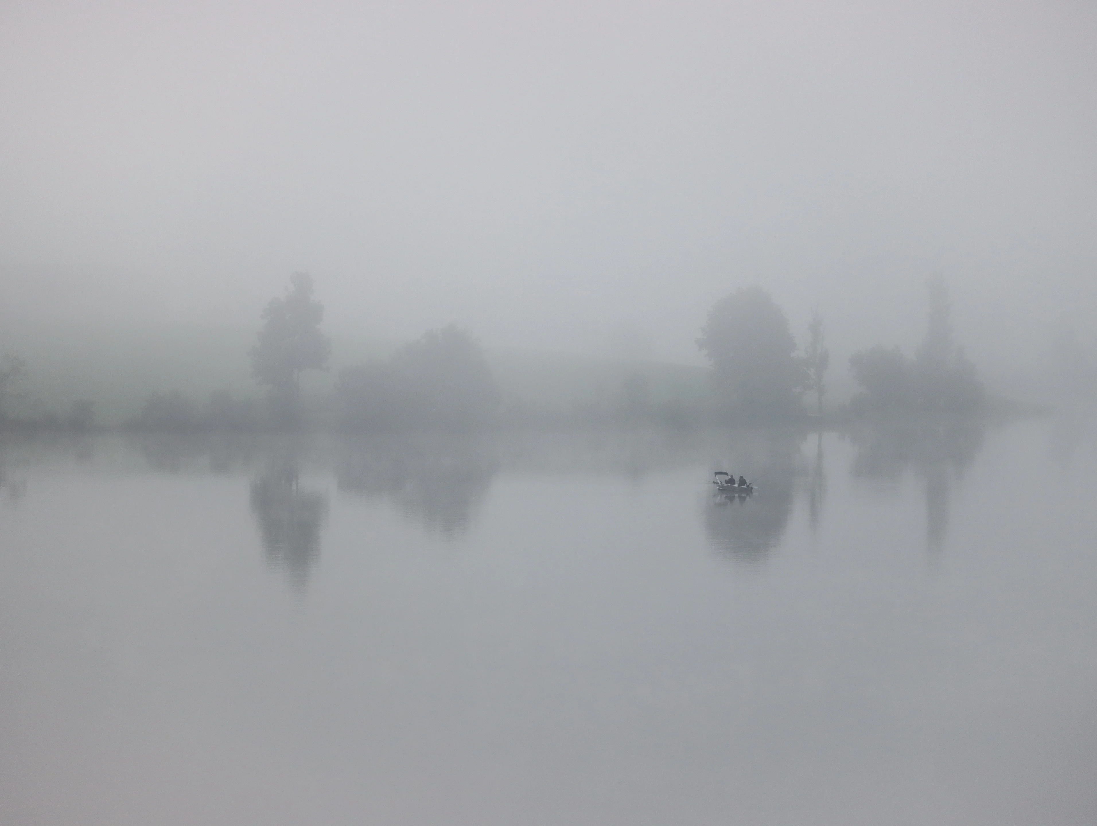 A silent lake veiled in pale mist