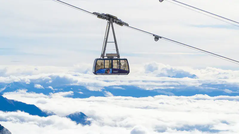 Cable car transiting over an Alpine cloud deck