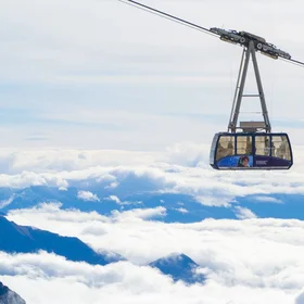 Cable car transiting over an Alpine cloud deck