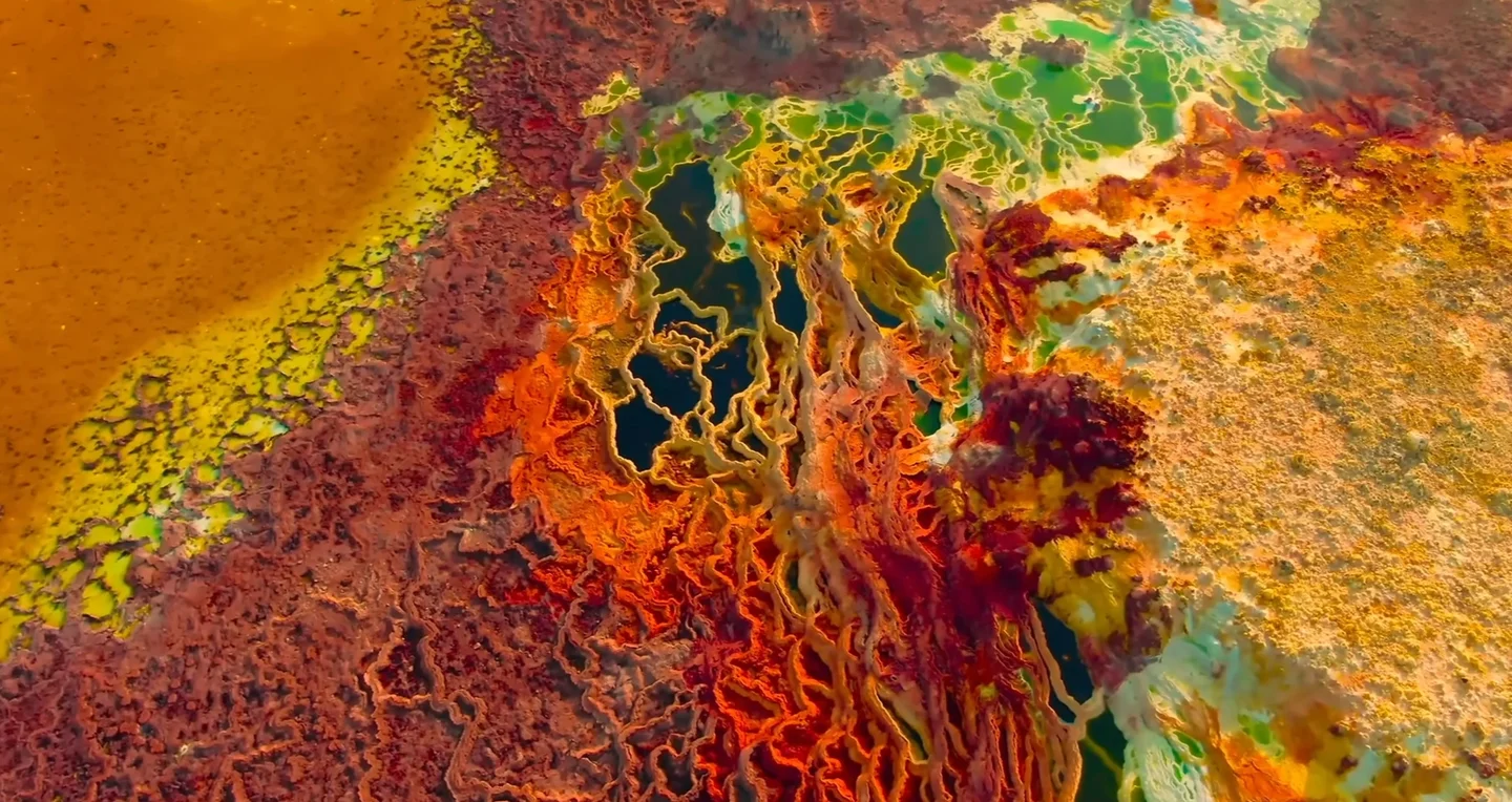 Colourful hydrothermal pools and mineral deposits in the Dallol geothermal area of the Danakil Depression, Afar Region, Ethiopia. The vivid yellow, orange, red and green surfaces reflect the unusual mineral-rich hydrothermal environment created by geother